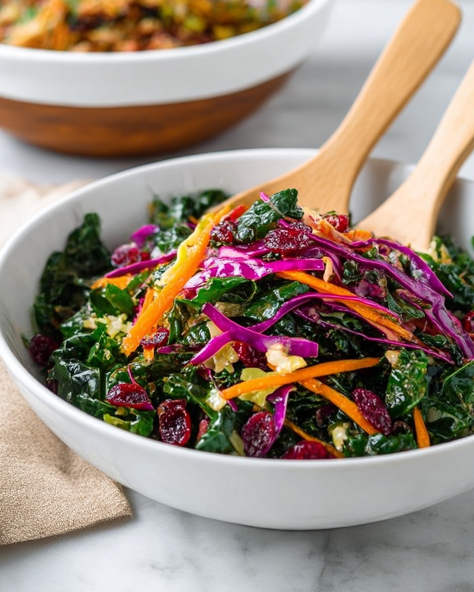 A white bowl filled with a colorful salad made of dark green kale leaves as the base layer, topped with thin strips of bright purple cabbage, thin orange shredded carrots, and scattered red dried cranberries. There are also small bits of light yellow cabbage mixed in. Two light wooden salad spoons are placed inside the bowl, resting on top of the vegetables. The bowl is set on a white marbled surface with a blurred white bowl containing a brown dish in the background. photo taken with an iphone --ar 4:5 --v 7