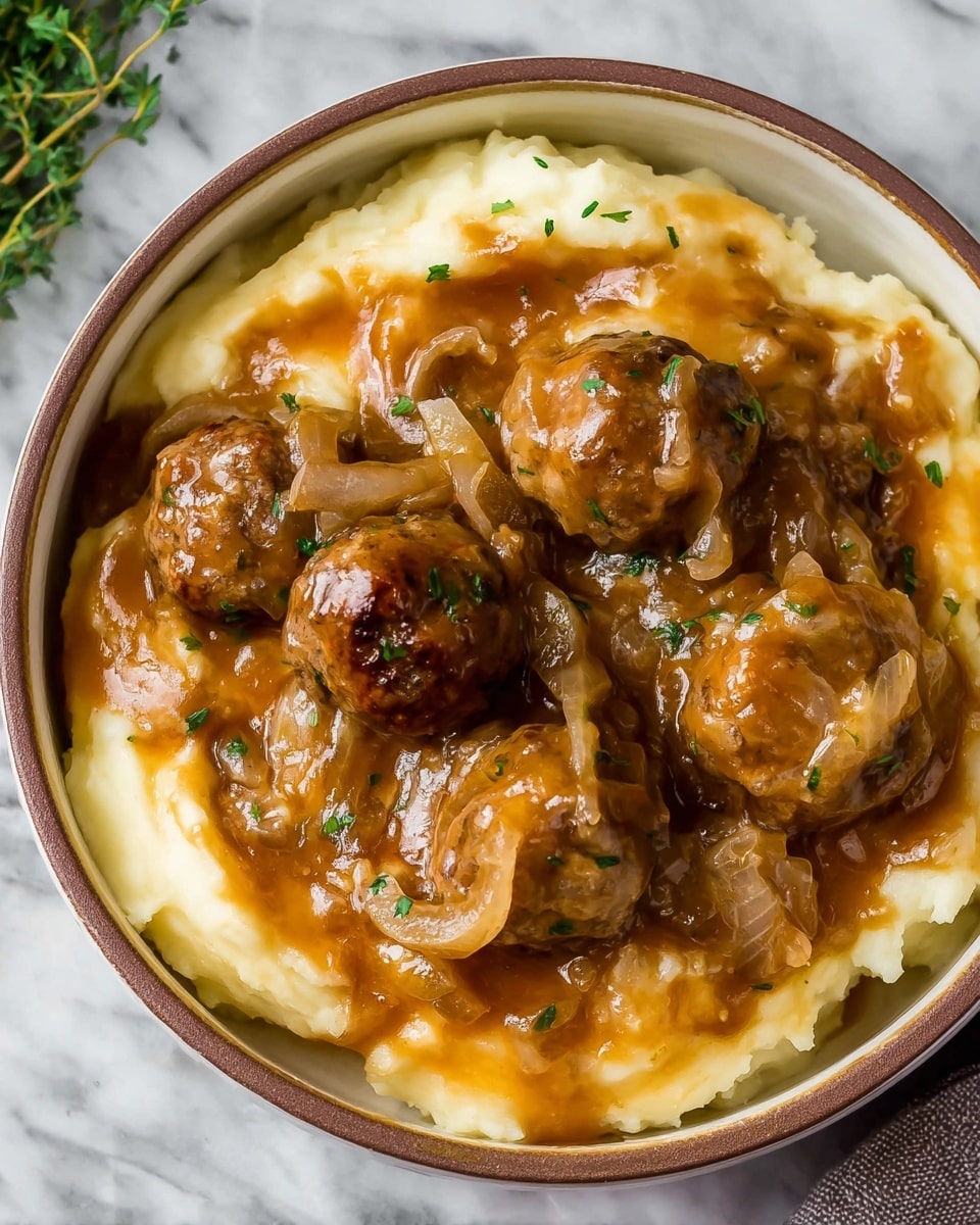 A bowl with a smooth layer of creamy mashed potatoes at the bottom, pale yellow in color, topped with a thick layer of brown gravy mixed with tender meatballs and soft cooked onions. The gravy is glossy and coats the meatballs and onions well, with small bits of green herbs sprinkled throughout. The bowl is white with a brown rim, placed on a white marbled surface with some green herbs nearby. Photo taken with an iphone --ar 4:5 --v 7