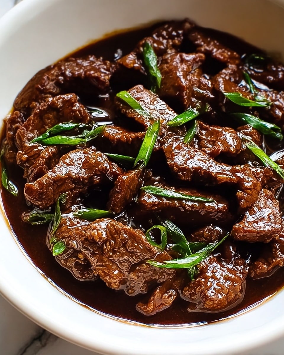 This image shows a white bowl filled with dark brown beef strips cooked in a shiny, thick sauce. The beef pieces have a slightly rough texture and are mixed with small green onion slices. The sauce covers the beef well and reflects light, making the dish look rich and glossy. The bowl sits on a white marbled surface. photo taken with an iphone --ar 4:5 --v 7