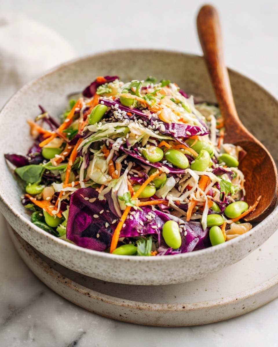 A bowl filled with a colorful salad containing four main layers: the base has shredded light green cabbage and purple cabbage pieces; next, bright orange shredded carrots mix with green edamame beans and pale beige white beans spread evenly; sprinkled over are white sesame seeds with fresh green cilantro leaves scattered on top, all inside a white bowl with a subtle speckled texture, and a wooden spoon stands on the right side of the bowl, resting on a white marbled textured surface. photo taken with an iphone --ar 4:5 --v 7